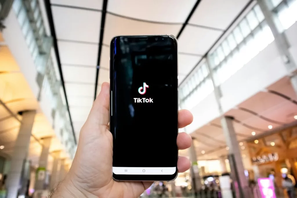 Smartphone z włączoną aplikacją TikTok, w tle galeria handlowa