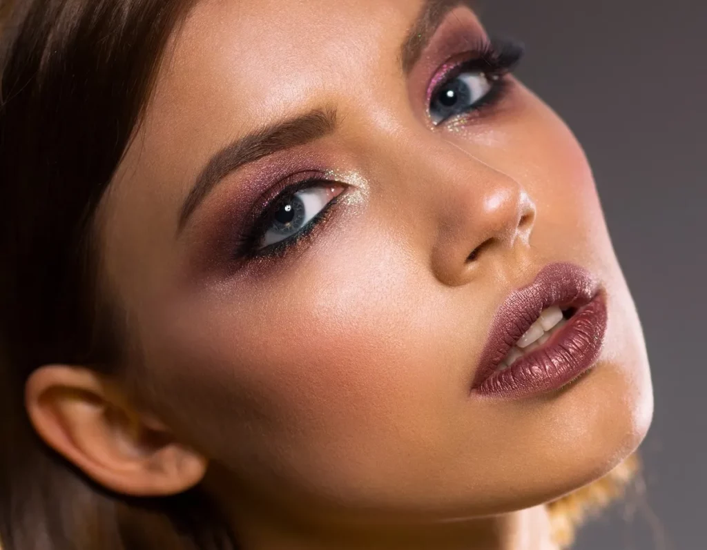 Zbliżenie na kobiecą twarz z mocnym makijażem w stylu full glam