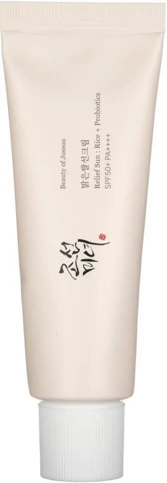 Tubka kremu przeciwsłonecznego stoi pionowo na jasnym tle, z koreańską etykietą i SPF50+.