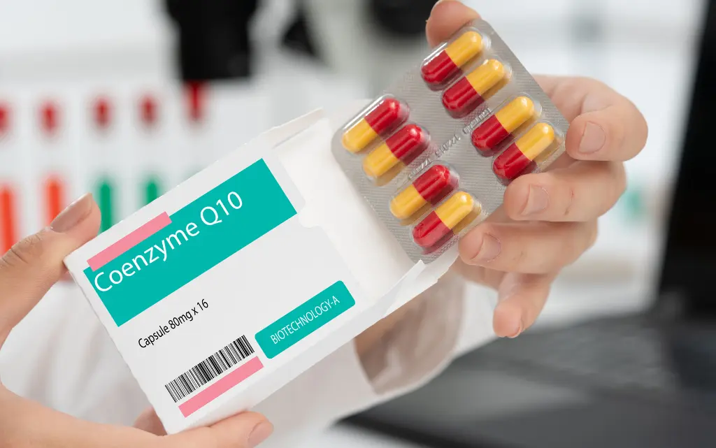 Farmaceuta trzyma opakowaniu koenzymu Q10  w tabletkach 