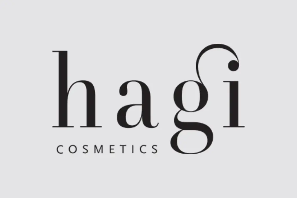 Logo "hagi" napisane smukłą, ozdobną czcionką, z napisem "COSMETICS" pod spodem na jasnym tle.
