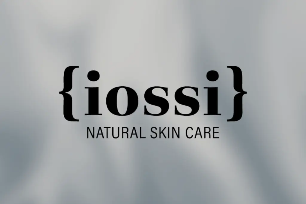 Logo „iossi” otoczone klamrami, prezentuje slogan „Natural Skin Care” na miękkim szarym tle.