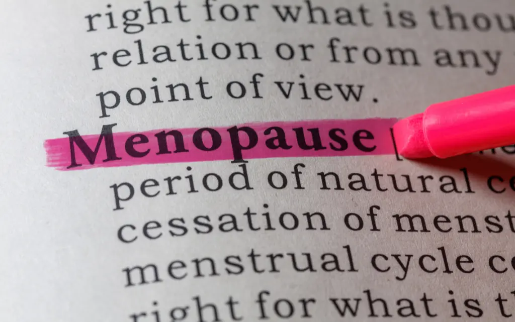 Napis w gazecie „menopauza” z podkreśleniem na różowo 