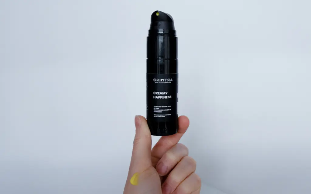 SkinTra Creamy Happiness – Emulsja z Retinalem 0,1% w Cyklodekstrynach trzymane w dłoni - zdjęcie.