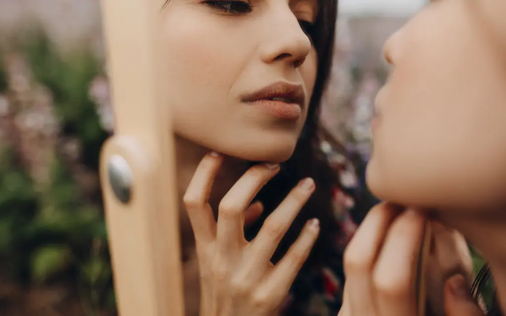Dziewczyna w makijażu soft Focus makeup przygląda się w lustrze