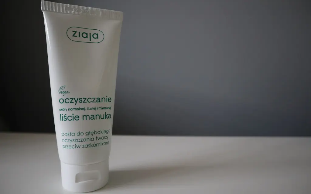 Pasta do głębokiego oczyszczania Ziaja liście manuka na tle szarej ściany 