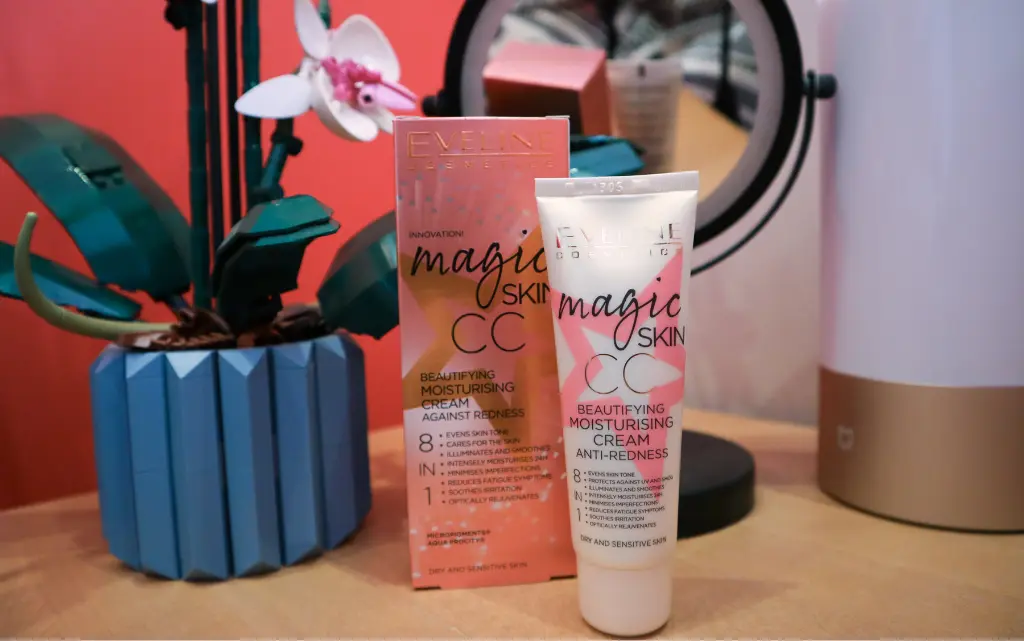 Krem Eveline Magic Skin CC na tle lusterka, lampki oraz kwiatka orchidei LEGO