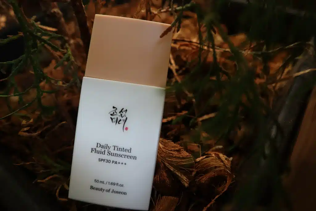 Krem na słońce Daily Tinted Fluid Sunscreen Beauty of Joseon na tle kory drzewnej