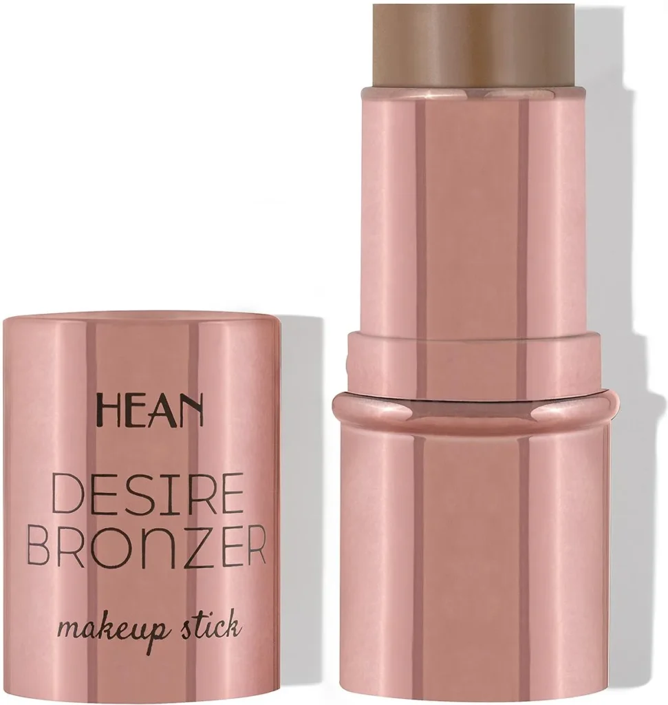 Bronzer w sztyfcie stoi obok zdjętej, różowo‑złotej nasadki na białym tle.