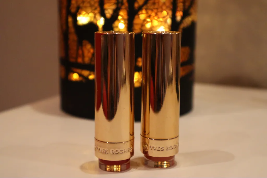 Dwie pomadki do ust Yves Rocher Grand Rouge na tle jesiennej lampki