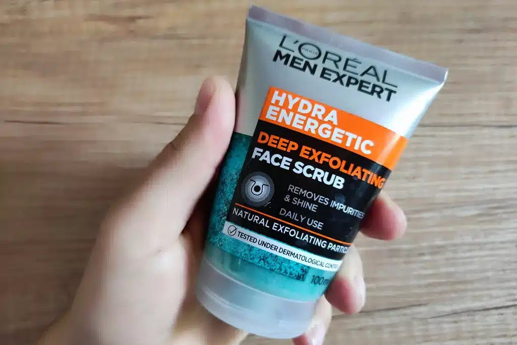 Męska dłoń trzymająca peeling do twarzy dla mężczyzn L’Oréal Men Expert Hydra Energetic Deep Exfoliating Face Scrub