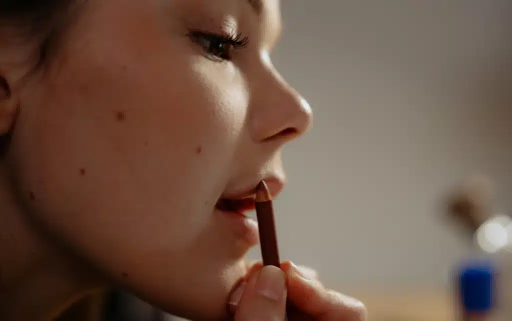 Młoda dziewczyna maluje usta konturówką 