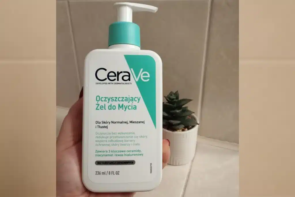 Kobieca dłoń trzyma opakowanie 236 ml żelu oczyszczającego do cery normalnej i tłustej CeraVe