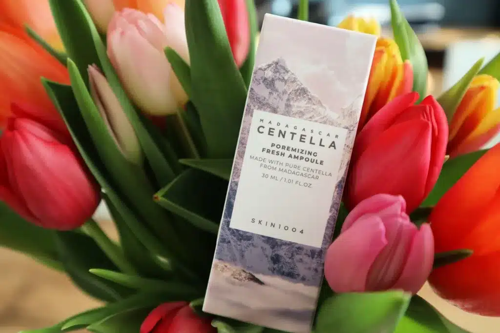 Koreańskie serum do zmniejszenia porów Skin1004 na tle tulipanów