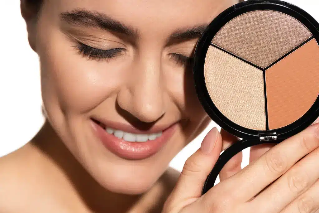 Kobieta z paletą do konturowania: bronzer, róż, rozświetlacz