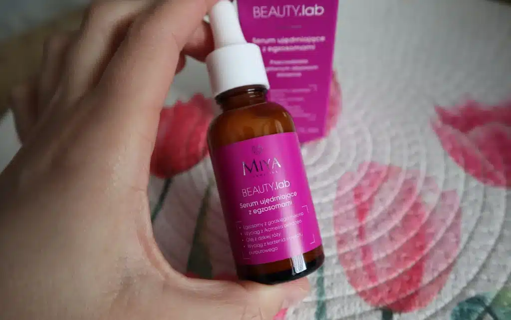 serum ujędrniające z egzosomami Miya Cosmetics BEAUTY.lab  w kobiecej dłoni na tle dekoracyjnej podkładki