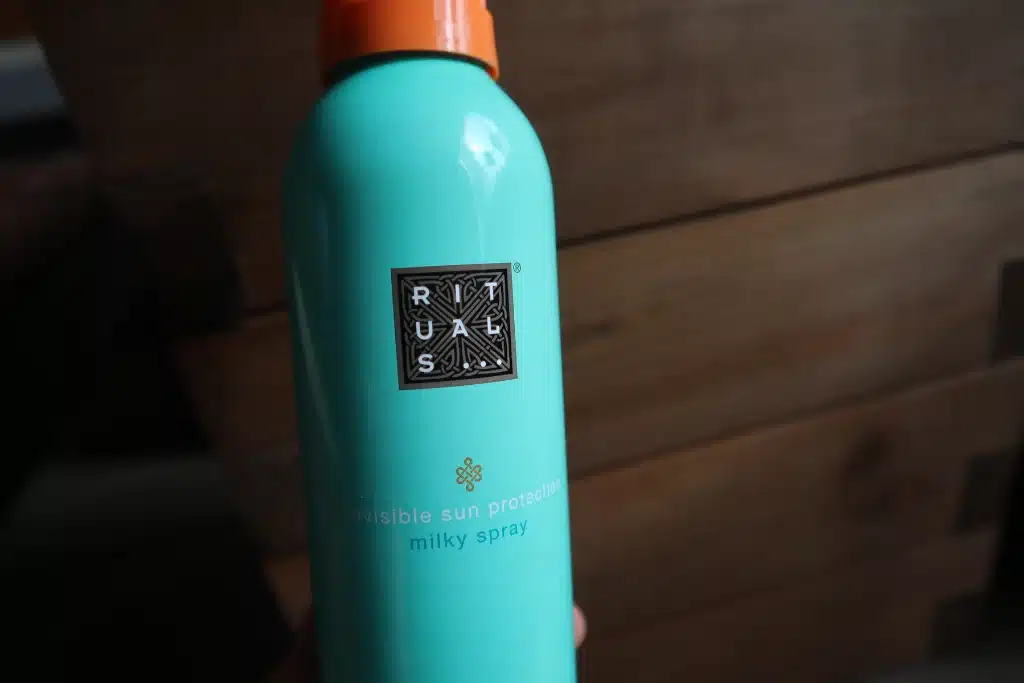 Mleczko do opalania w sprayu The Rituals of Karma SPF 30 na drewnianym tle