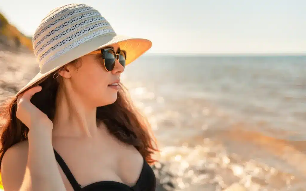 Młoda kobieta w kapeluszu na plaży 