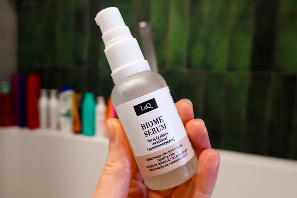 Serum do twarzy z postbiotykami LaQ BIOME trzymane w kobiecej dłoni