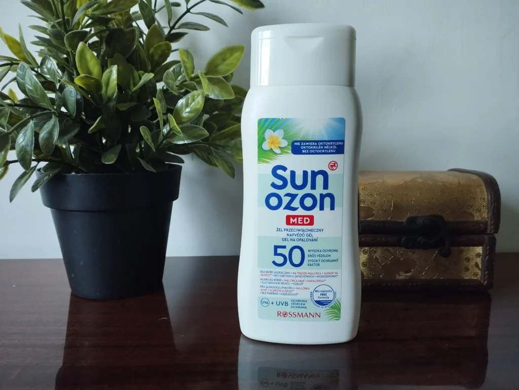 Sunozon Med Żel przeciwsłoneczny na komodzie, w tle roślinka i szkatułka